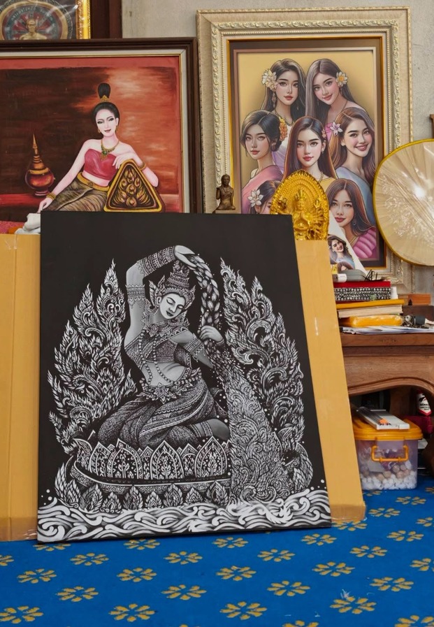 ผลงานลายเส้นขาวดำวางเรียงกลางแจ้ง