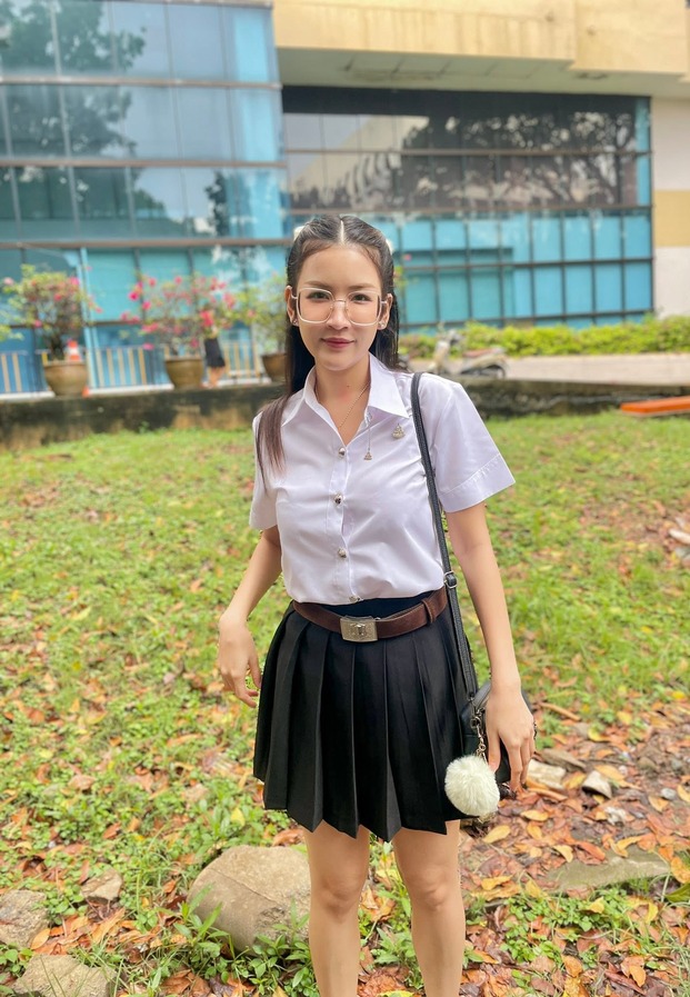 ทรีเนต ในชุดนักศึกษายืนถ่ายริมสนามหญ้า