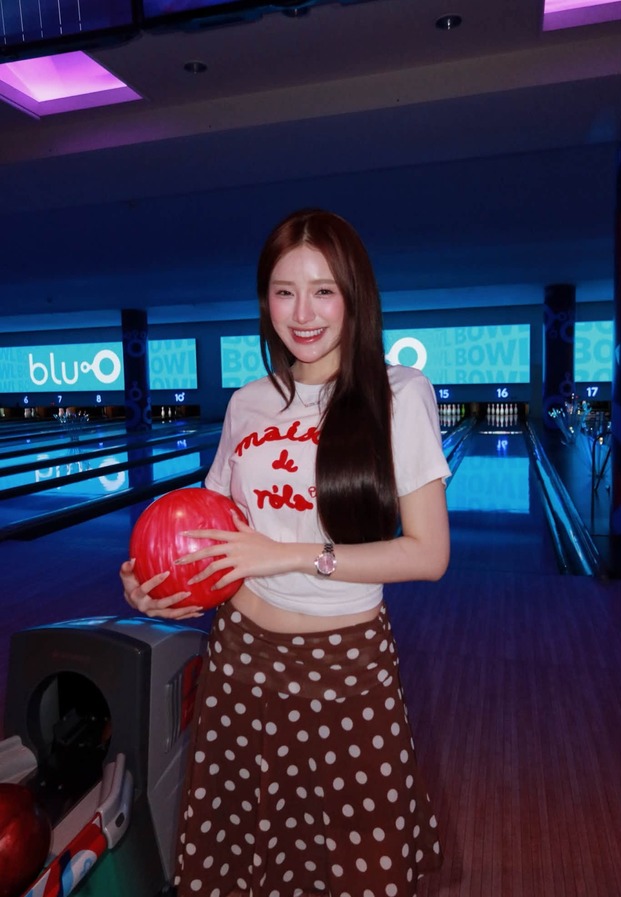 ยืนโพสต์กลางเลนโบว์ลิ่ง หน้าป้าย blu-O