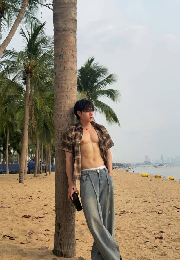 เสื้อลายสก็อตเปิดอกพิงต้นมะพร้าวริมหาด